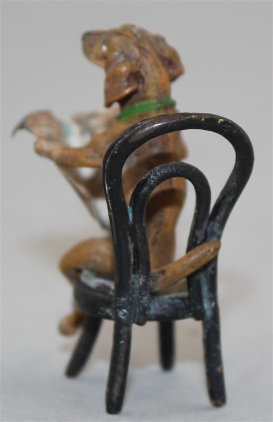 A miniature cold painted bronze model of a seated Dachshund reading a newspaper, in the manner of Franz Bergman, 2in.